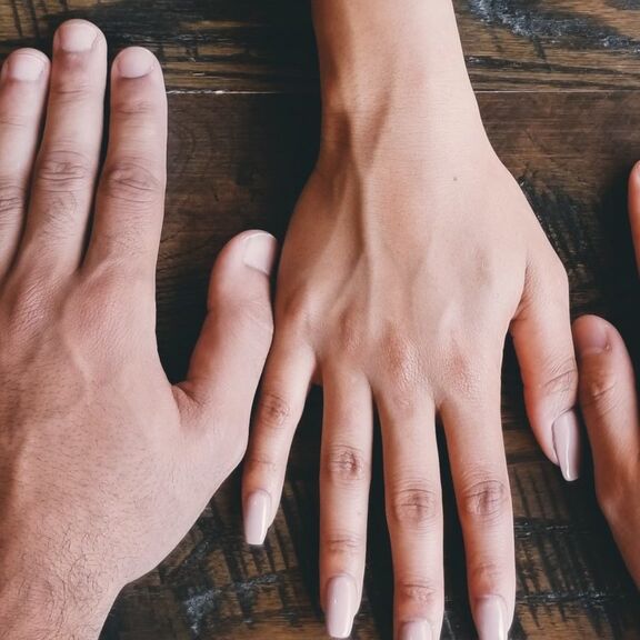 Five human hands on brown surface photo Five human hands on brown surface photo